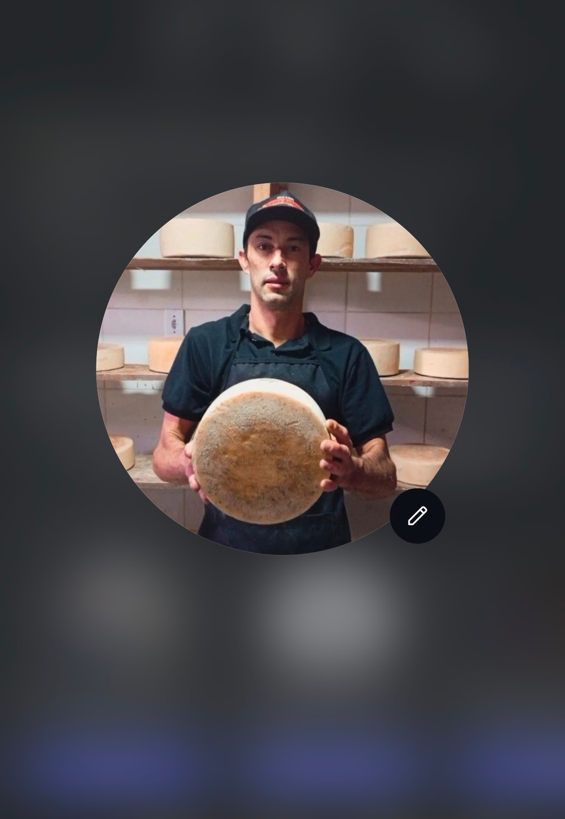 Produtor da Fazenda Santo Antônio segurando uma peça de queijo